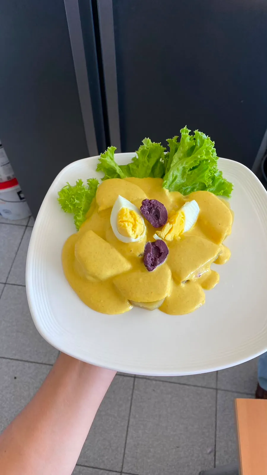 Papa a la huancaína con huevo y aceituna