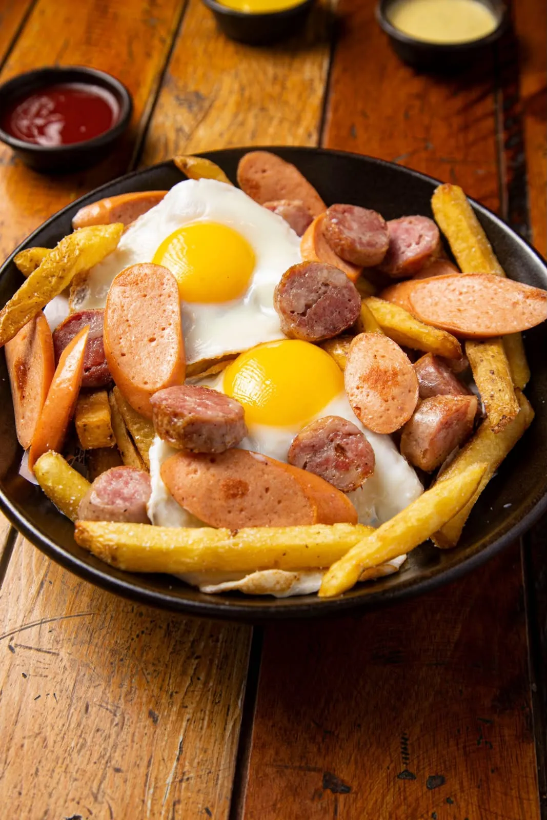 Salchipapa con huevos fritos