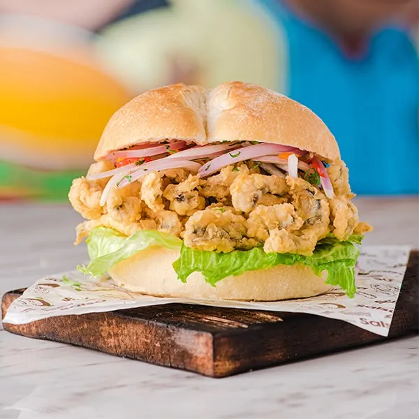 Sándwich de chicharrón de mariscos con salsa criolla